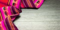 Multicolor bright pattern tablecloth on wooden table for background