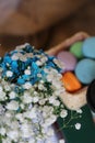 multicolor cookies in a box beside a bunch of white and blue flowers on books on a table