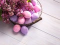 Multicolor Easter eggs and flowers of Lilac on wooden table. Top view