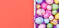 Multicolor eggs in a white tray. Creative Easter concept. Modern solid pink background. . Living coral theme - color of the year Royalty Free Stock Photo