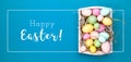 Multicolor eggs in a white tray. Creative Easter concept. Modern solid turquoise background.