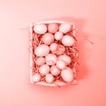 Multicolor eggs in a white tray. Creative Easter concept. Modern solid yellow background. . Living coral theme - color of the Royalty Free Stock Photo