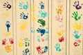 Multicolor paint handprints of children, teenagers and adults on wall
