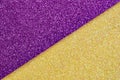 Multicolor paper diagonal background yellow, purple colors. Top view, copy space. Shiny multicolored festive background