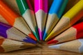 Multicolor pencils forming a color half circle isolated on wooden background.