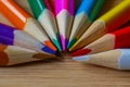 Multicolor pencils forming a color half circle isolated on wooden background.