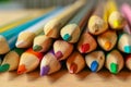 Multicolor pencils on wooden background.