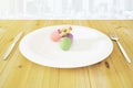 Multicolor pilsl in white roound plate with fork and knife on wooden table at city background