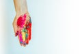 Multicolor powdered paints on palm. Concept of Holi, Indian spring festival. Image of female hand on white background, copy space Royalty Free Stock Photo