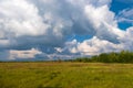 Multicolor rainbow on the background of a beautiful cloudy sky and a red church with a bell tower Royalty Free Stock Photo