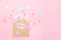 Multicolor sweets sugar candy hearts, handcraft paper flowers and cards with Hello April lettering fly out of craft paper envelope Royalty Free Stock Photo