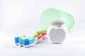 Multicolor toothbrushes and dental floss on white background