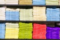 Multicolor towels on shelf in market, sale cotton towels, stack colored cotton