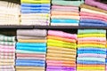 Multicolor towels on shelf in market, sale cotton towels, stack colored cotton