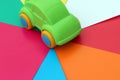 The toy car stands on a bright multicolored colorful background.