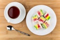 Multicolor Turkish delight in glass plate and cup of tea
