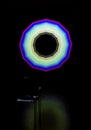 Multicolor umbrella-shaped circle placed in a dark room in front of a chair