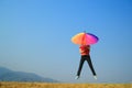 Multicolor umbrella woman jumping to sky