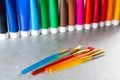 Multicolored acrylic paints tubes set with five colorful brushes