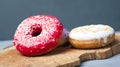 Multicolored assorted red,white,violet donuts coated with glaze and sprinkled with Easter powder on a wooden standn