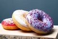 Multicolored assorted red,white,violet donuts coated with glaze and sprinkled with Easter powder on a wooden standn