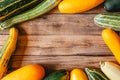 Multicolored assorted zucchini on a wooden table. The view from the top. Space for text