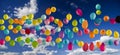 Multicolored balloons soar into the sky. Against the blue sky with white clouds