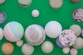 Multicolored bath bombs on a green background, top view.