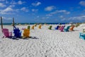 Multicolored beach chairs on a white beach, facing the ocean Royalty Free Stock Photo