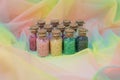 Multicolored beads in glass jars with cork isolated on a colored background Royalty Free Stock Photo