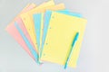 Multicolored blank checkered pages from a folding notebook in different pastel colors scattered on silver desk