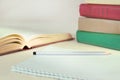 Multicolored books, stacked up and an open book, next to notebook. Concept of education, knowledge and self-development Royalty Free Stock Photo