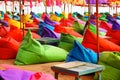 Multicolored bright beach umbrellas, ottomans and tables in the beach cafe. Summer multicolored background Royalty Free Stock Photo