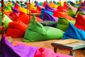 Multicolored bright beach umbrellas, ottomans and tables in the beach cafe. Summer multicolored background Royalty Free Stock Photo