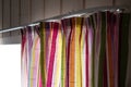 Multicolored bright curtain on the cornice, on the window.