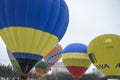 Multicolored bright round colored striped flying balloons with a basket against the sky Aeronautics festival