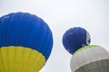 Multicolored bright round colored striped flying balloons with a basket against the sky. Aeronautics festival