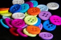 Multicolored buttons lie on a black background Royalty Free Stock Photo