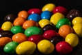 Multicolored candies on a black background close-up