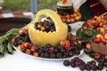 Multicolored cherries in a melon basket and around a jar of cherry jam.