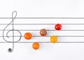 Multicolored cherry tomatoes on the musical staff. Creative food background Royalty Free Stock Photo