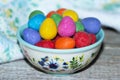 Multicolored chocolate Easter eggs in a ceramic bowl on the table Royalty Free Stock Photo