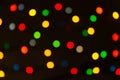 Multicolored circular bokeh lights on dark black background. Christmas holiday lights