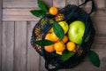 Multicolored citrus fruits in textile bag on old wooden table. Healthy food and zero waste concept Royalty Free Stock Photo