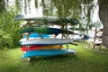 Multicolored colorful kayaks stored upside down on outdoor wood vertical storage rack Royalty Free Stock Photo