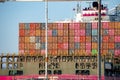 Multicolored containers loaded on ship at Port of Oakland with sky in background