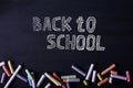 Multicolored crayons lie on a black chalkboard, copy space. The concept of school, education and childhood Royalty Free Stock Photo