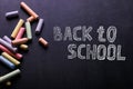 Multicolored crayons lie on a black chalkboard, copy space. The concept of school, education and childhood Royalty Free Stock Photo