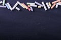 Multicolored crayons lie on a black chalkboard, copy space. The concept of school, education and childhood Royalty Free Stock Photo