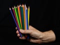Multicolored crayons on man hand Royalty Free Stock Photo